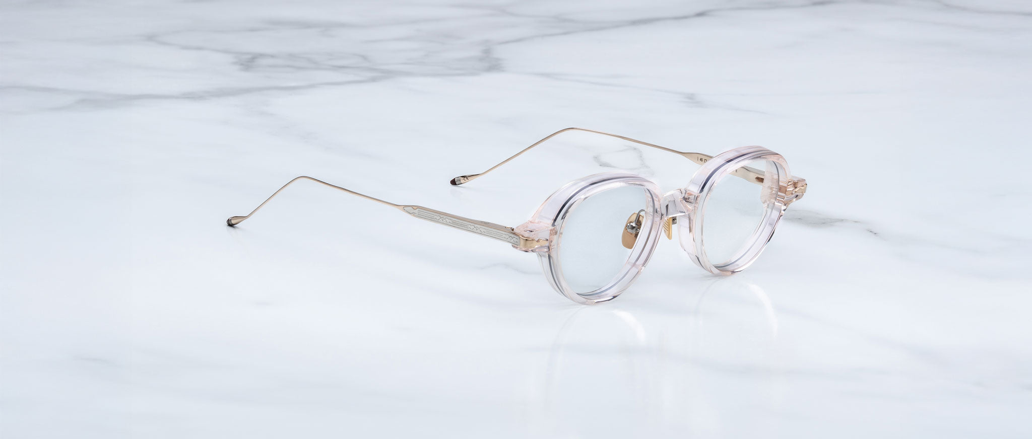Jacques Marie Mage The Clark eyeglasses with round clear frames and thin gold arms, shown from the front angle.