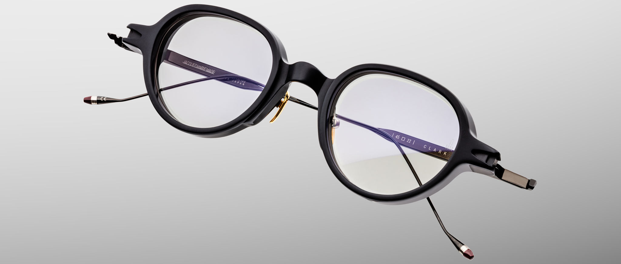 Jacques Marie Mage The Clark eyeglasses feature clear lenses and slim metal arms, shown from the front.