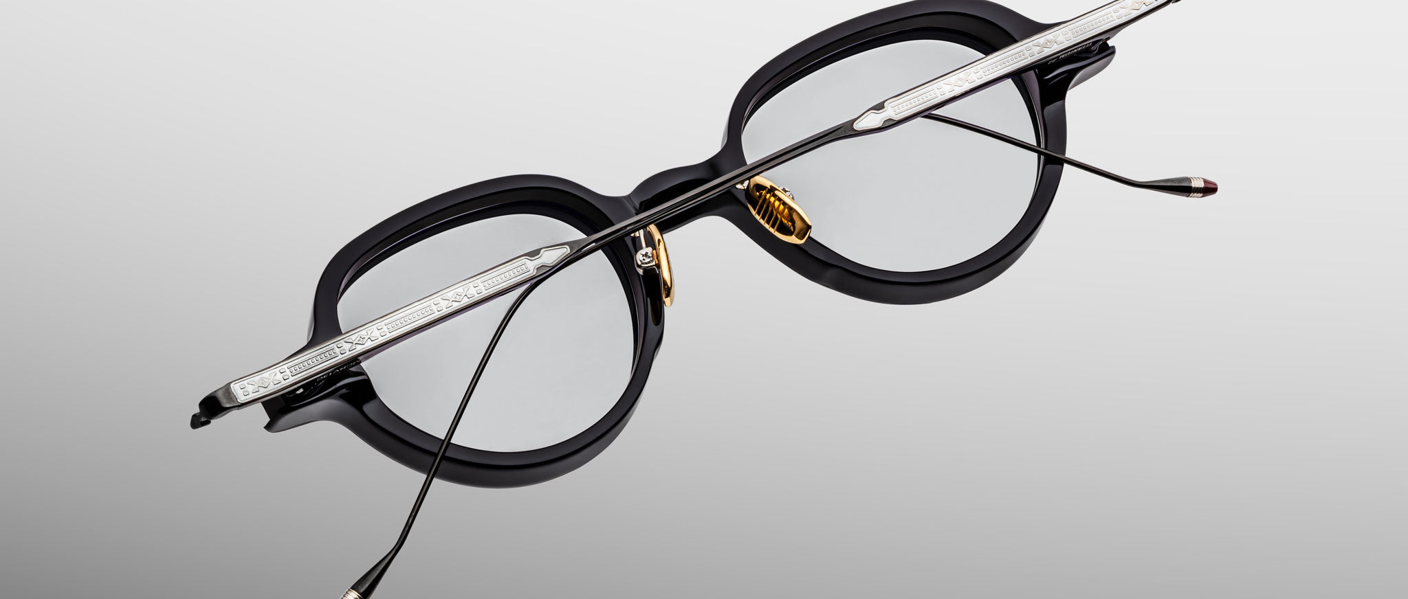 Jacques Marie Mage The Clark eyeglasses with black rims, gold nose pads, and silver temples shown from the front angle.