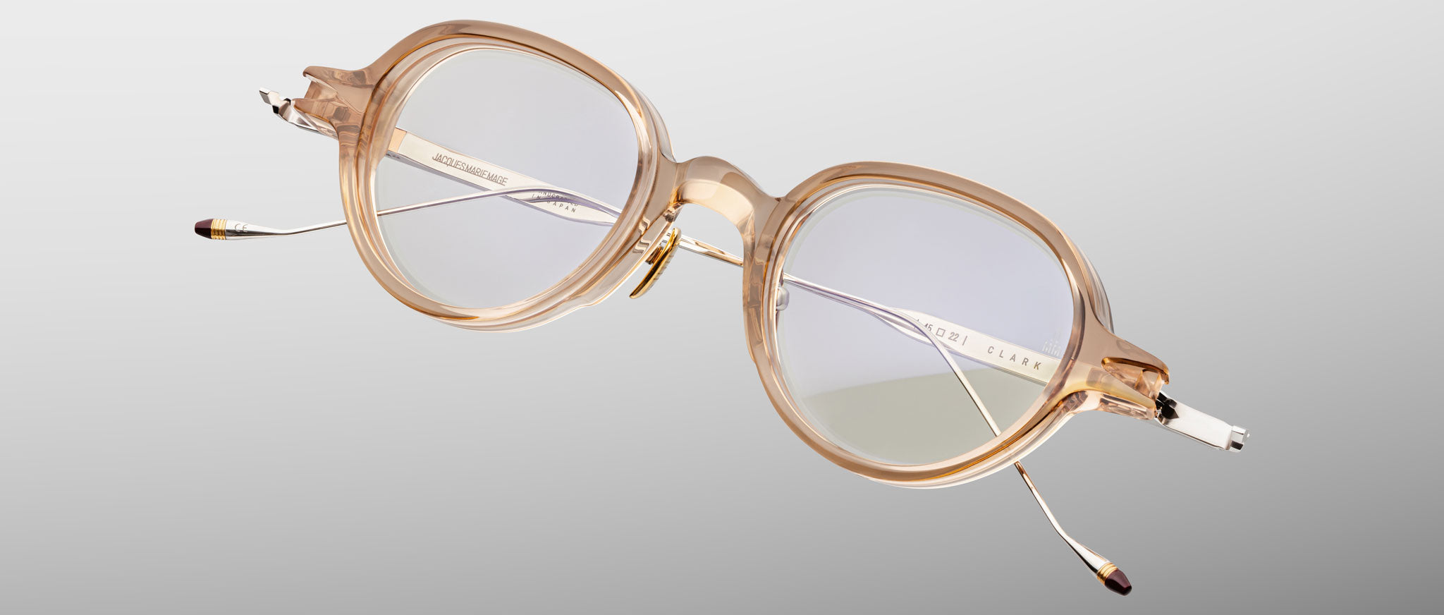 Jacques Marie Mage The Clark eyeglasses, clear beige round frames with silver arms, shown from the front.