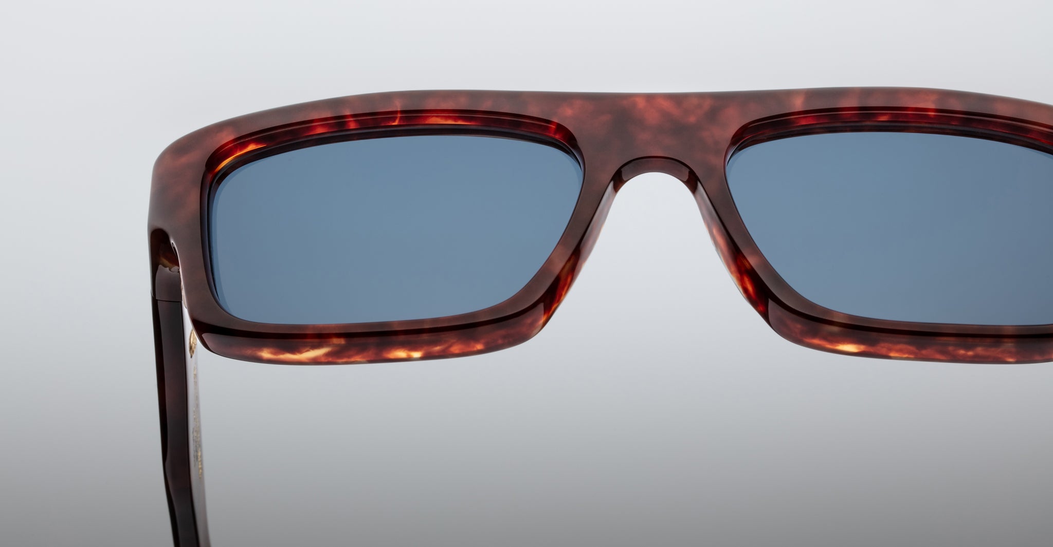 Close-up of Jacques Marie Mage Cleavon 57 rectangular sunglasses with tortoiseshell frame and blue-tinted lenses.