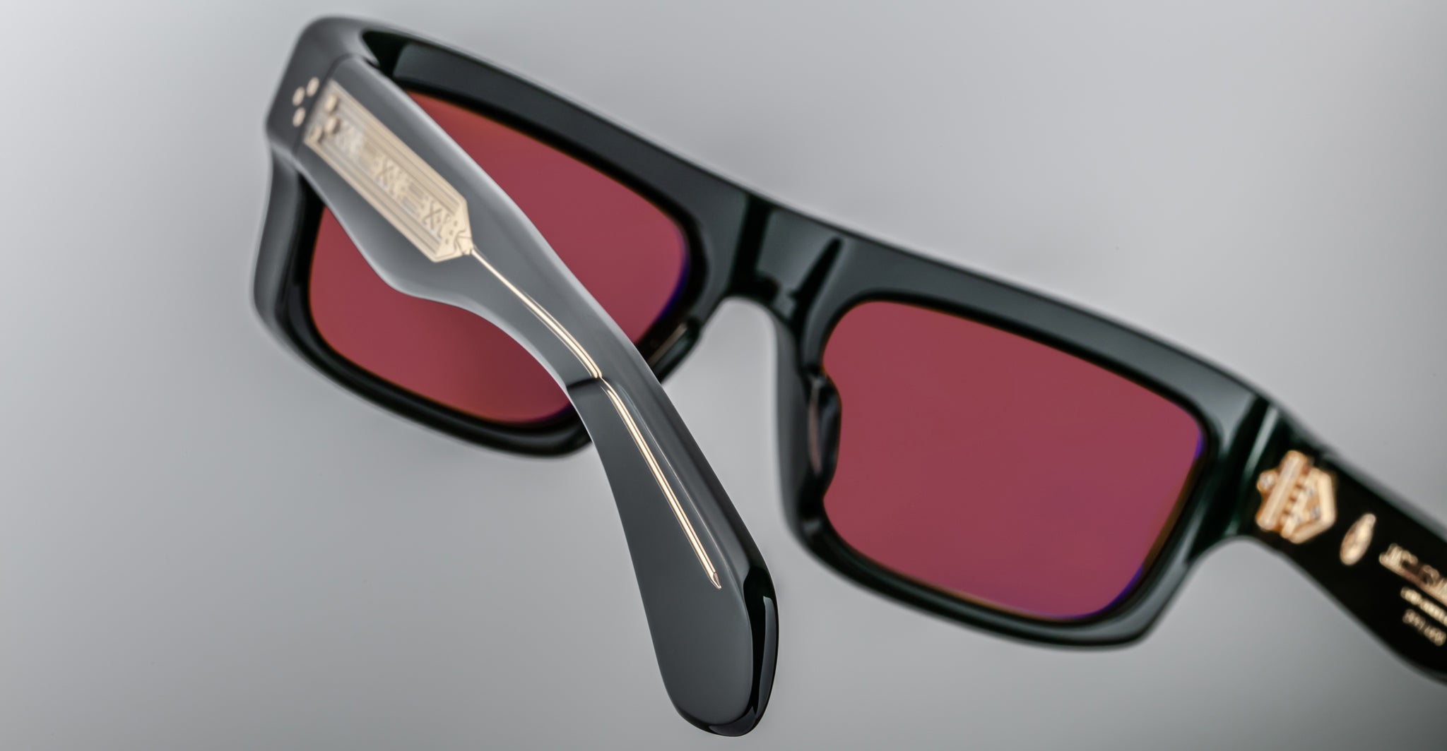 Jacques Marie Mage Cleavon 57 sunglasses with black frame, red-tinted lenses, and metallic accent at the temples, front view.