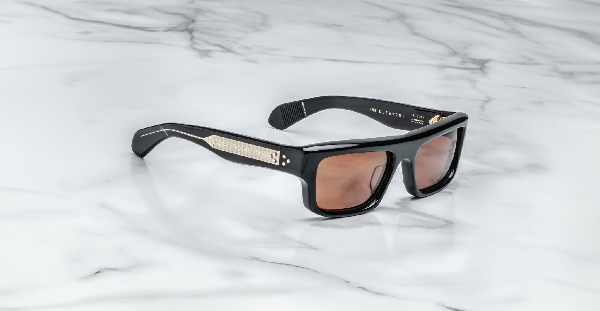 Jacques Marie Mage Cleavon 57 black rectangular sunglasses with gold accents, shown from above.