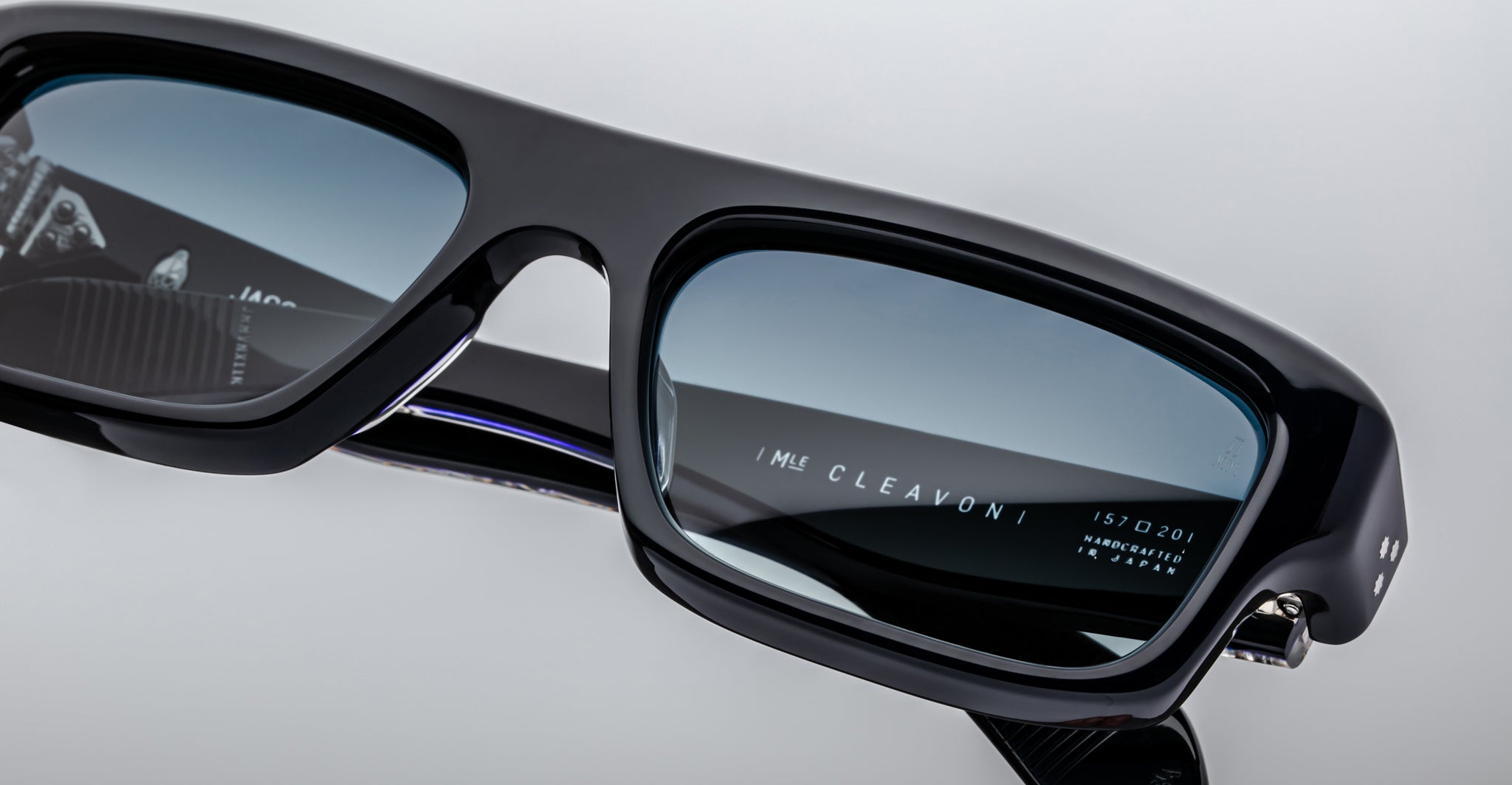 Close-up of Jacques Marie Mage Cleavon 57 black eyeglasses with blue light lenses, featuring engraved text on the temple arm.