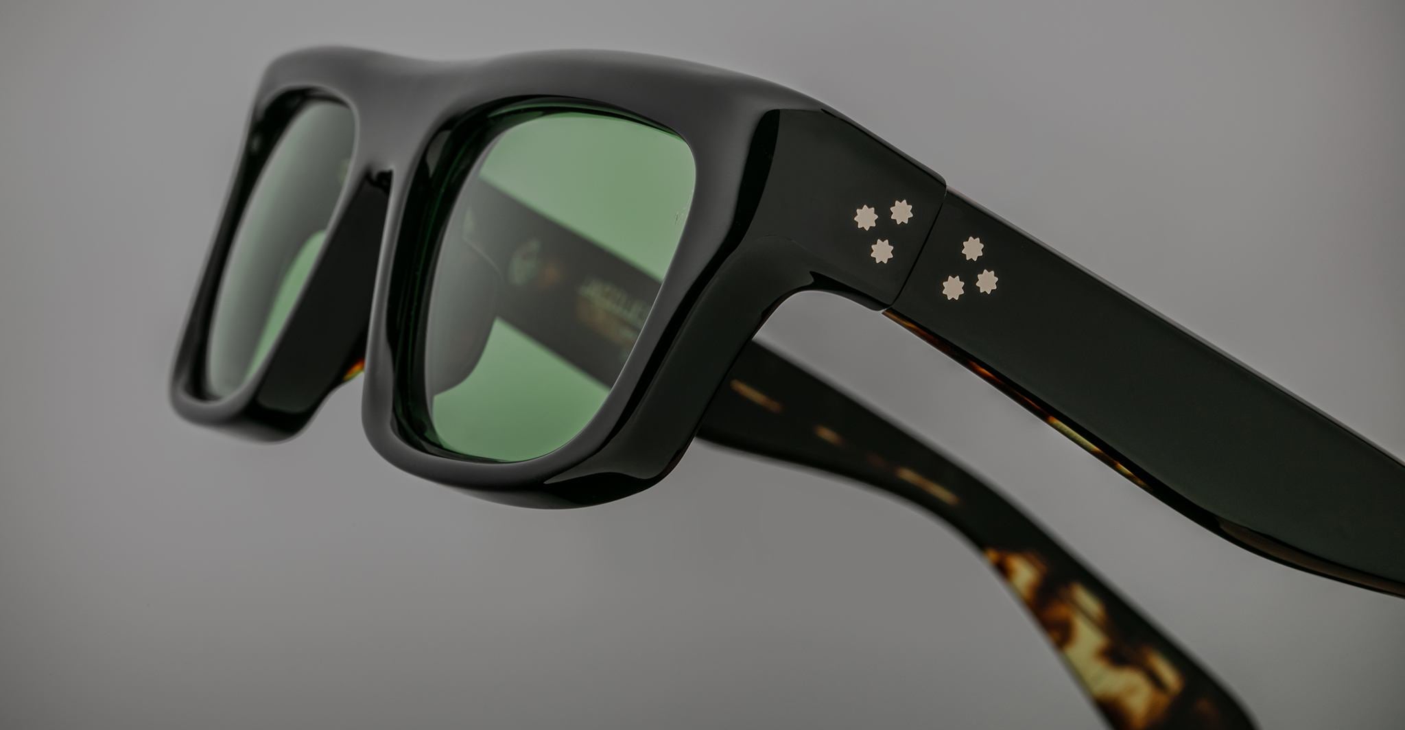 Jacques Marie Mage Cleavon black sunglasses, close-up view, featuring green lenses and white dot accents on the frame.