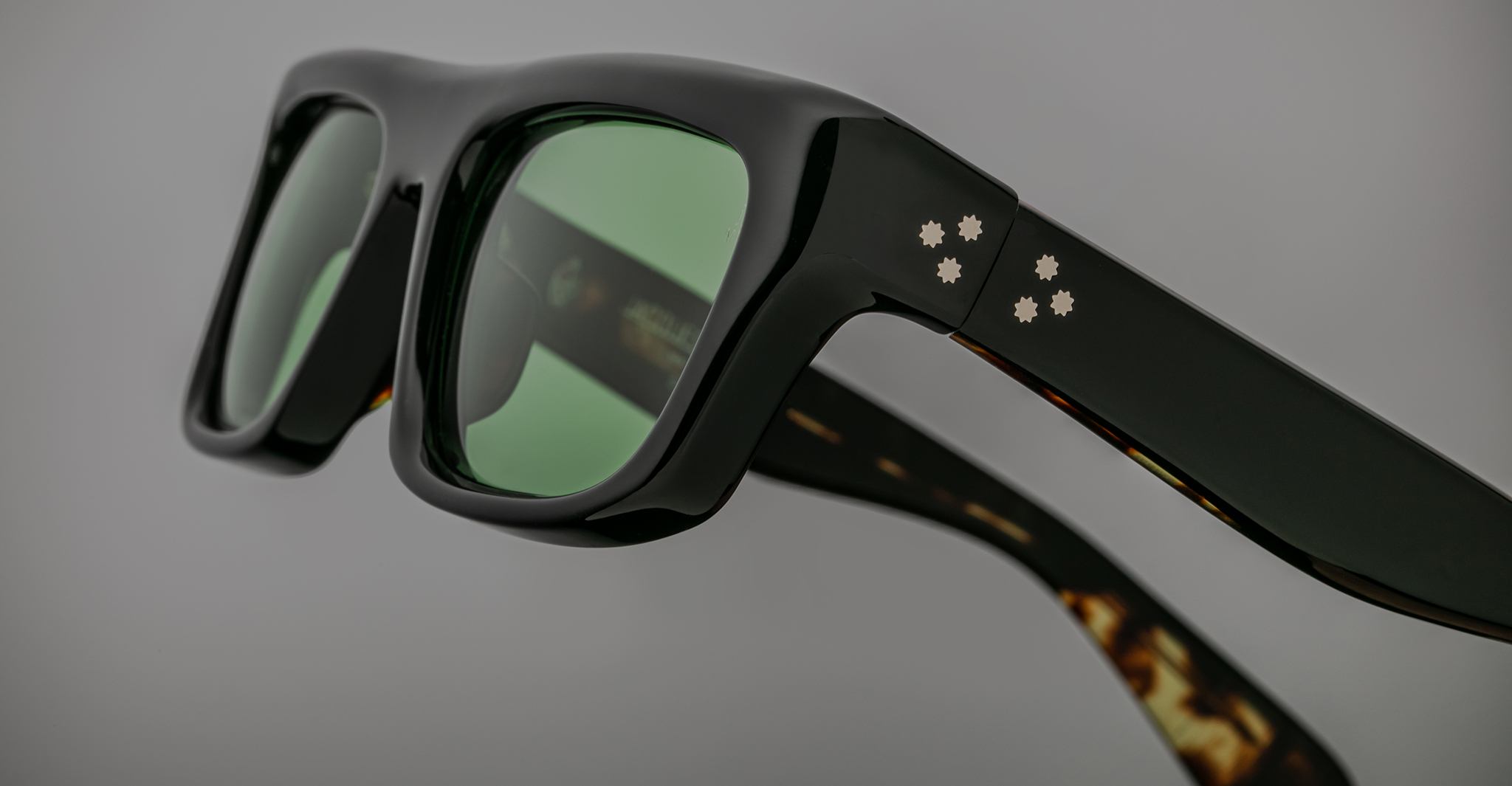 Jacques Marie Mage Cleavon black sunglasses, close-up view, featuring green lenses and white dot accents on the frame.