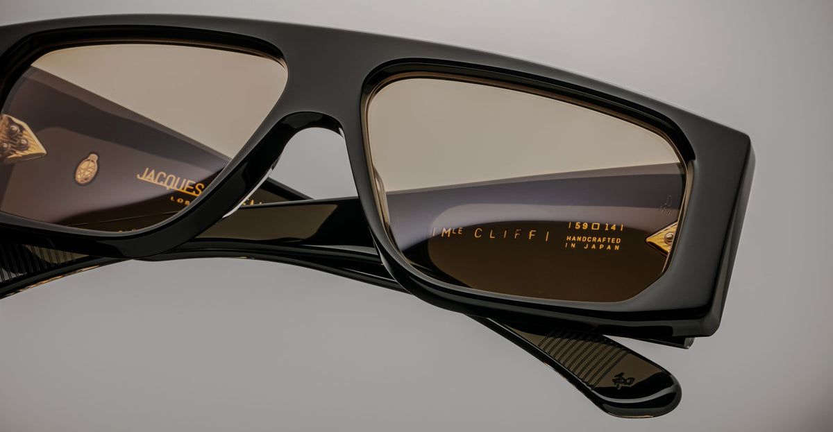 Close-up of Jacques Marie Mage Cliff black rectangular sunglasses with brown lenses, shown from the front.
