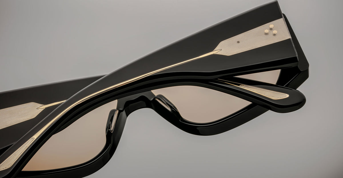Close-up of Jacques Marie Mage Cliff black sunglasses, gold accents visible on frame, product shown from the front angle.