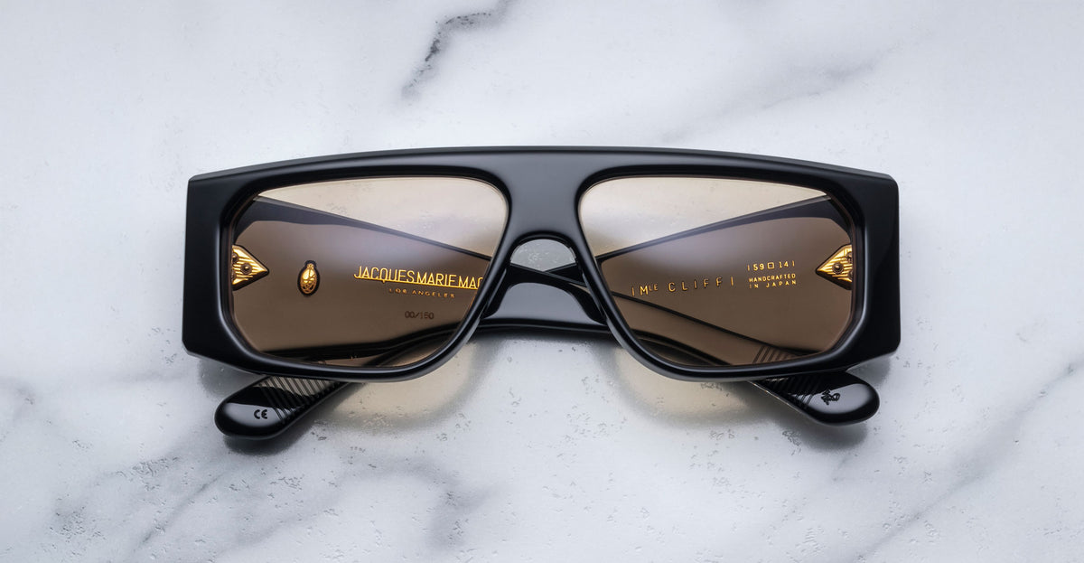 Jacques Marie Mage Cliff sunglasses, black frame with brown lenses, folded, top view.
