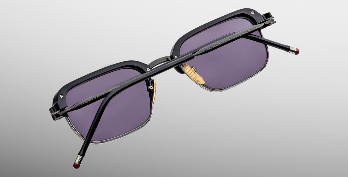 Jacques Marie Mage Comanche in Corbeau black rectangular sunglasses with purple-tinted lenses, viewed from the back.