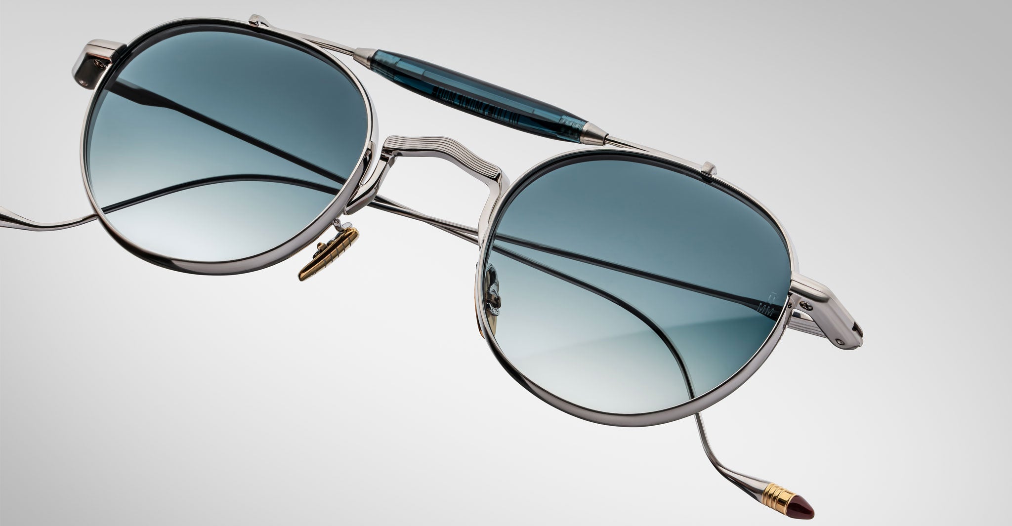 Detailed front view of the Jacques Marie Mage Dasan titanium sunglass in silver with blue gradient lenses on a white background