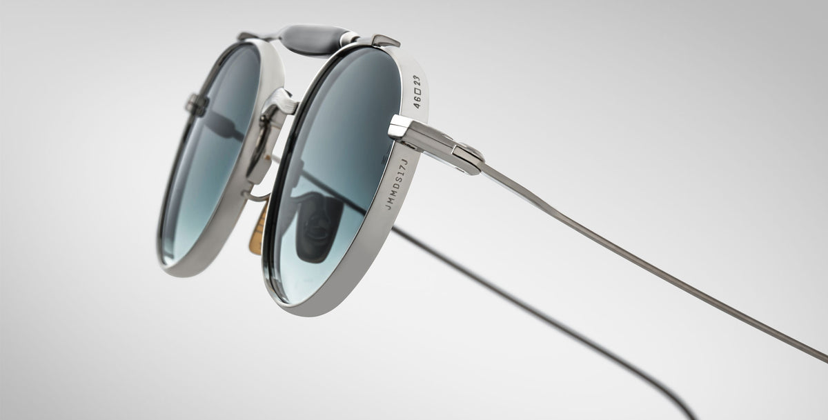 Detailed profile view of the Jacques Marie Mage Dasan titanium sunglass in silver with blue gradient lenses on a white background