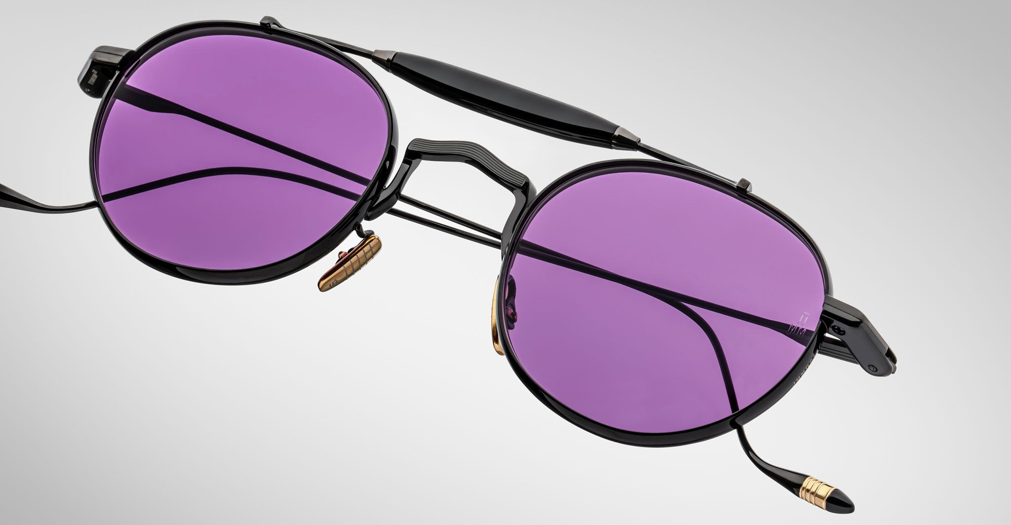 Detailed front view of the Jacques Marie Mage Dasan titanium sunglass in black color with purple lenses on a white background