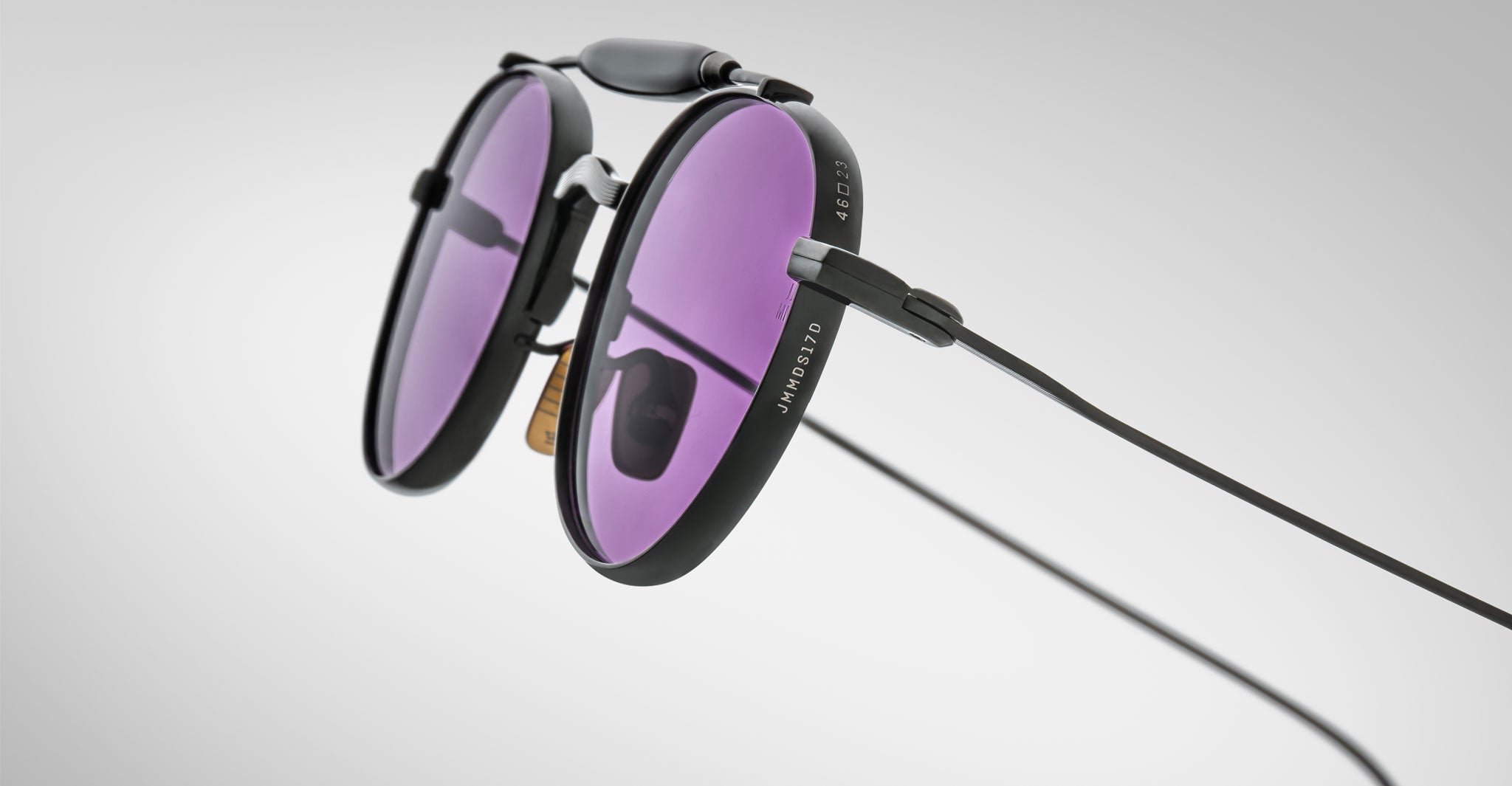 Detailed profile view of the Jacques Marie Mage Dasan titanium sunglass in black color with purple lenses on a white background