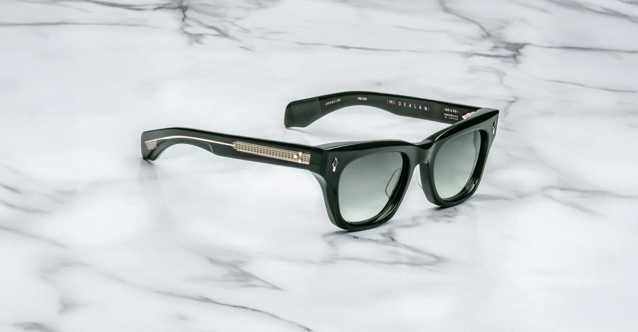 Jacques Marie Mage Dealan black sunglasses with dark lenses and metallic arms, shown from above.