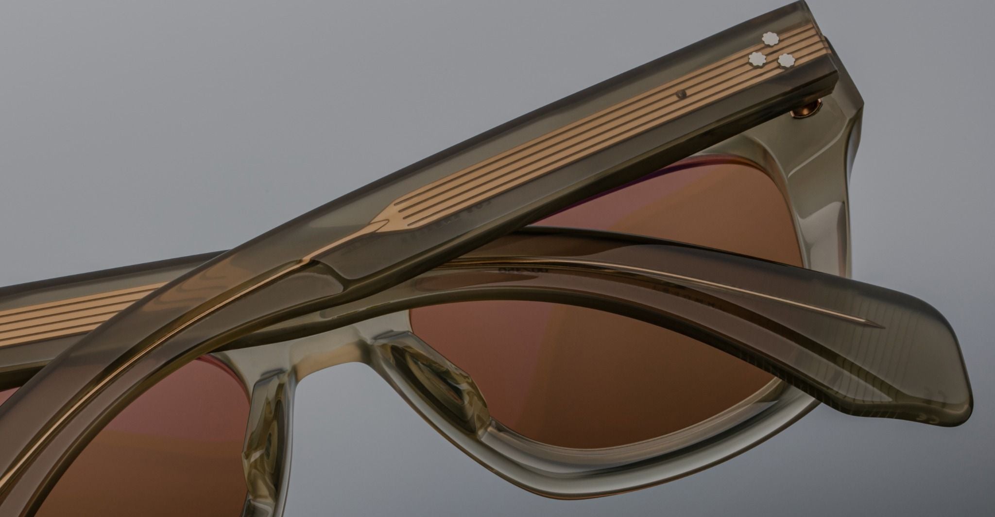 Close-up of two pairs of Jacques Marie Mage Dealan sunglasses, showing striped arms from a top angle.