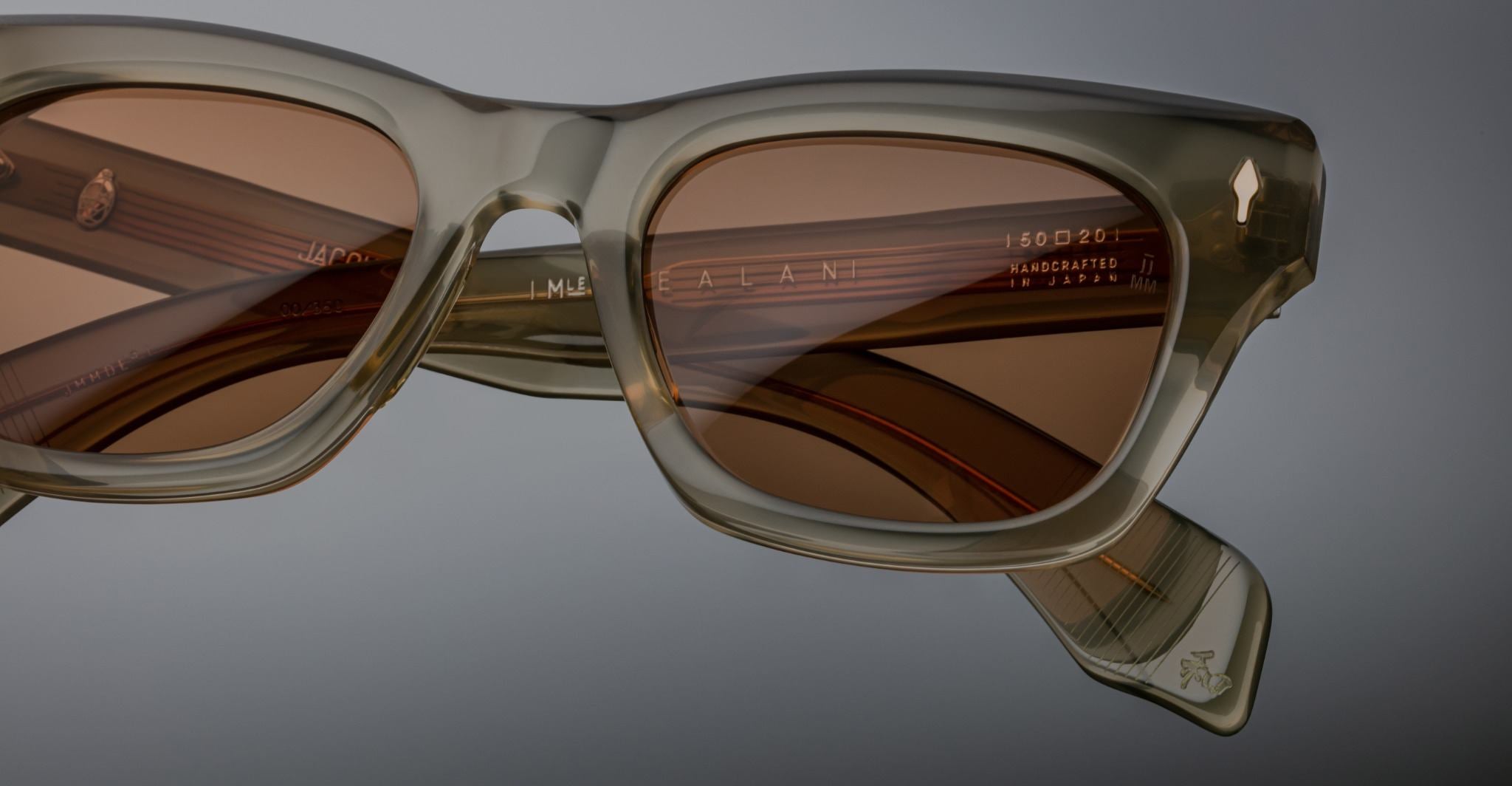 Close-up of Jacques Marie Mage Dealan sunglasses in translucent beige, brown lenses, and visible inner arm detailing.
