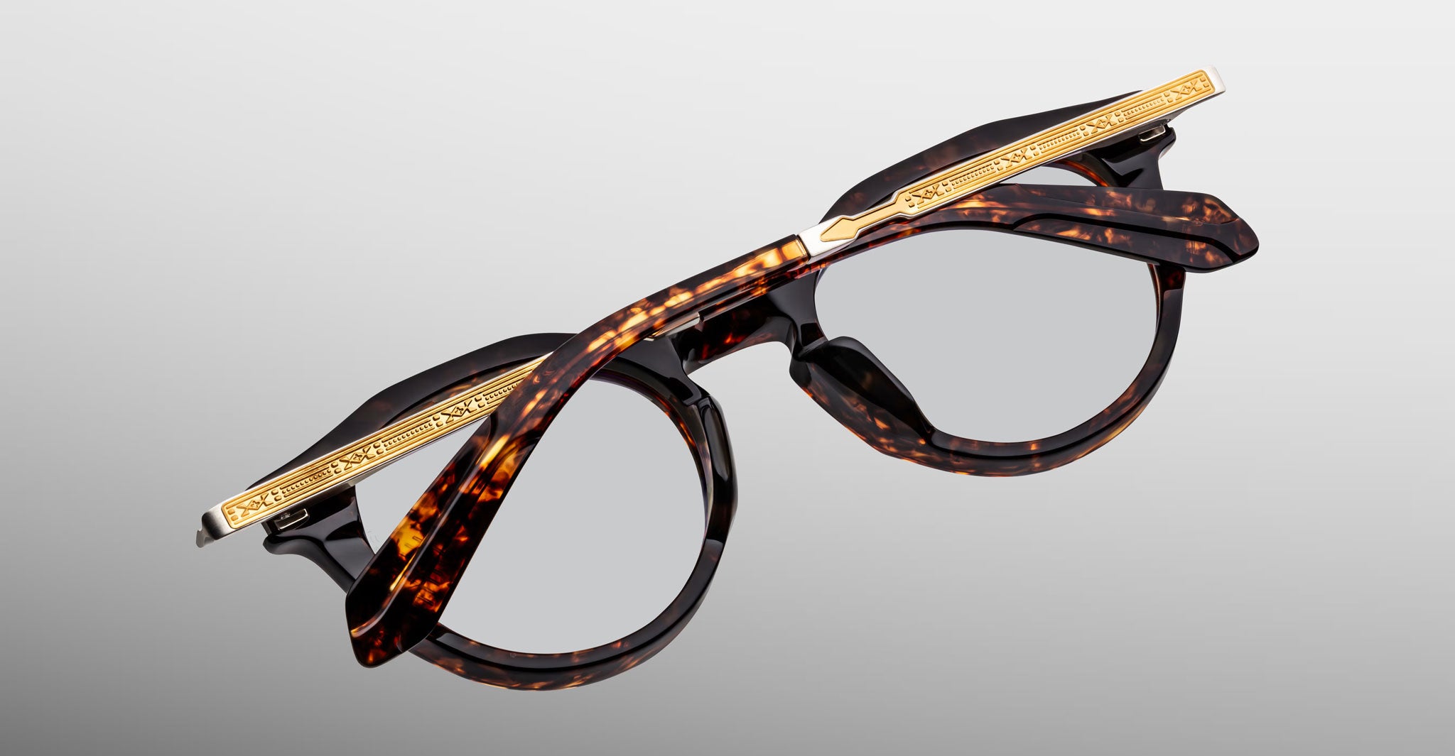 Close-up of Jacques Marie Mage Desnos tortoiseshell rectangular eyeglasses with gold accents, front angle view.