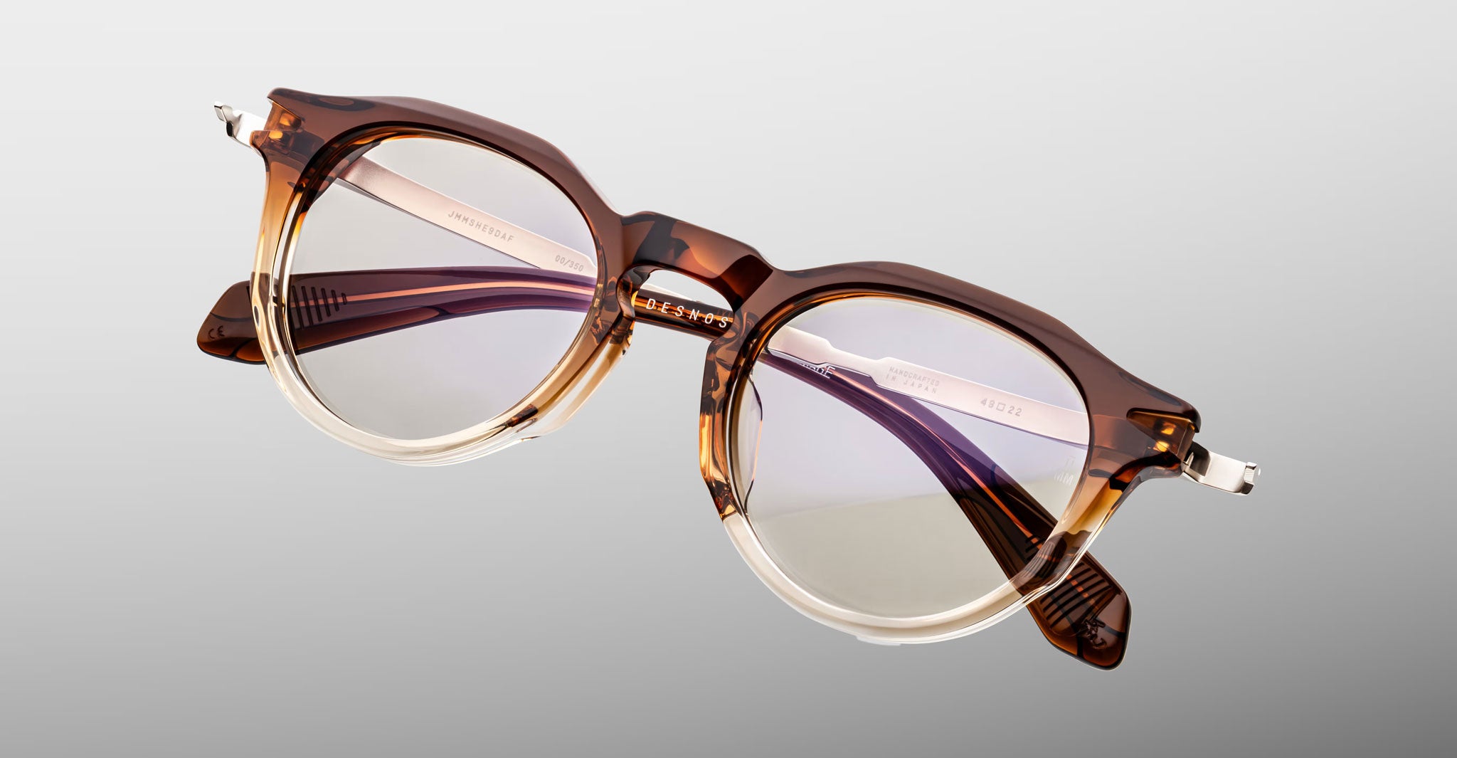 Jacques Marie Mage Desnos round eyeglasses in brown and clear acetate, shown at an angle.