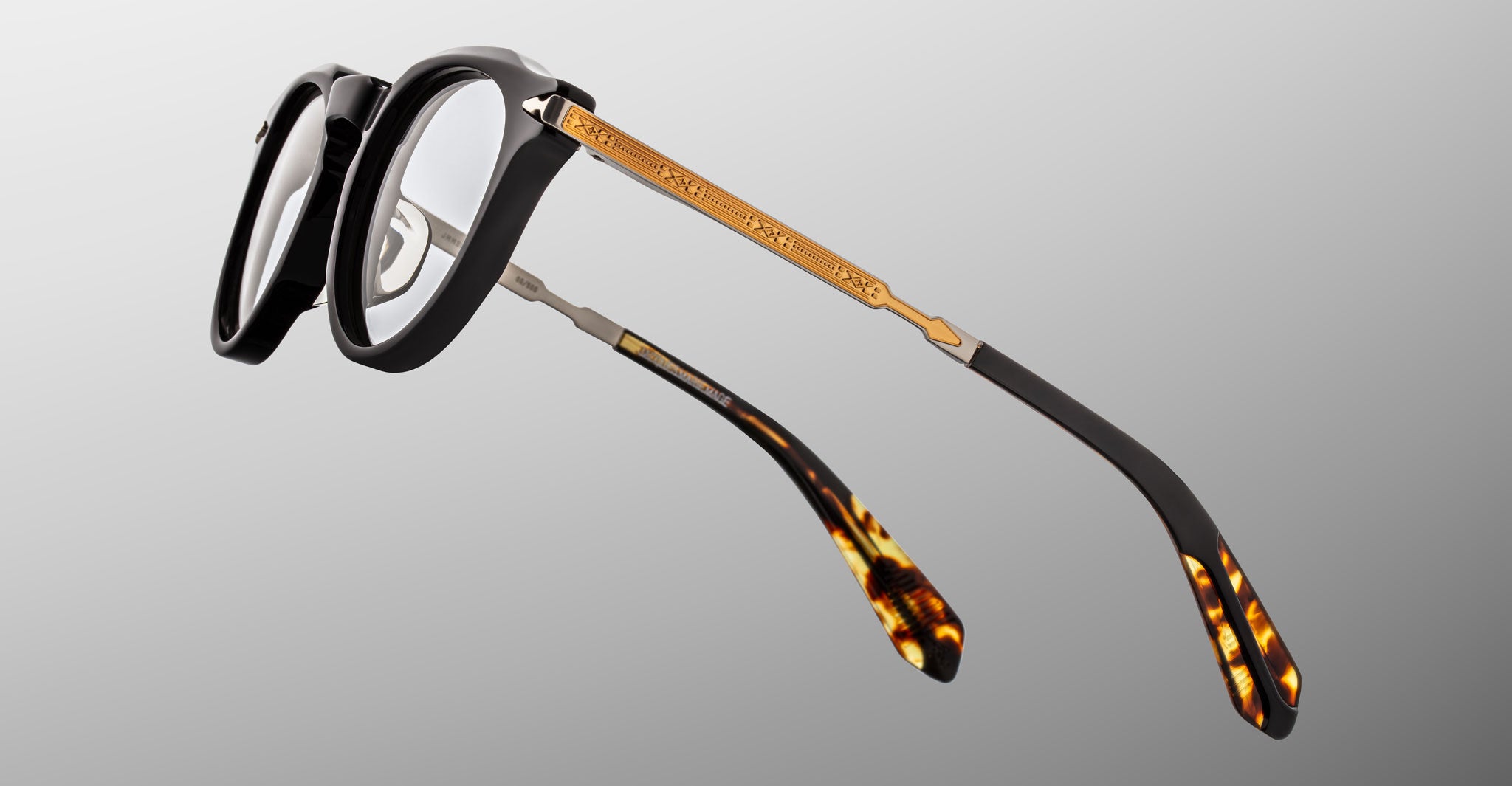 Jacques Marie Mage Desnos eyeglasses, front view: black frame with clear lenses, gold temples, and tortoiseshell acetate tips.