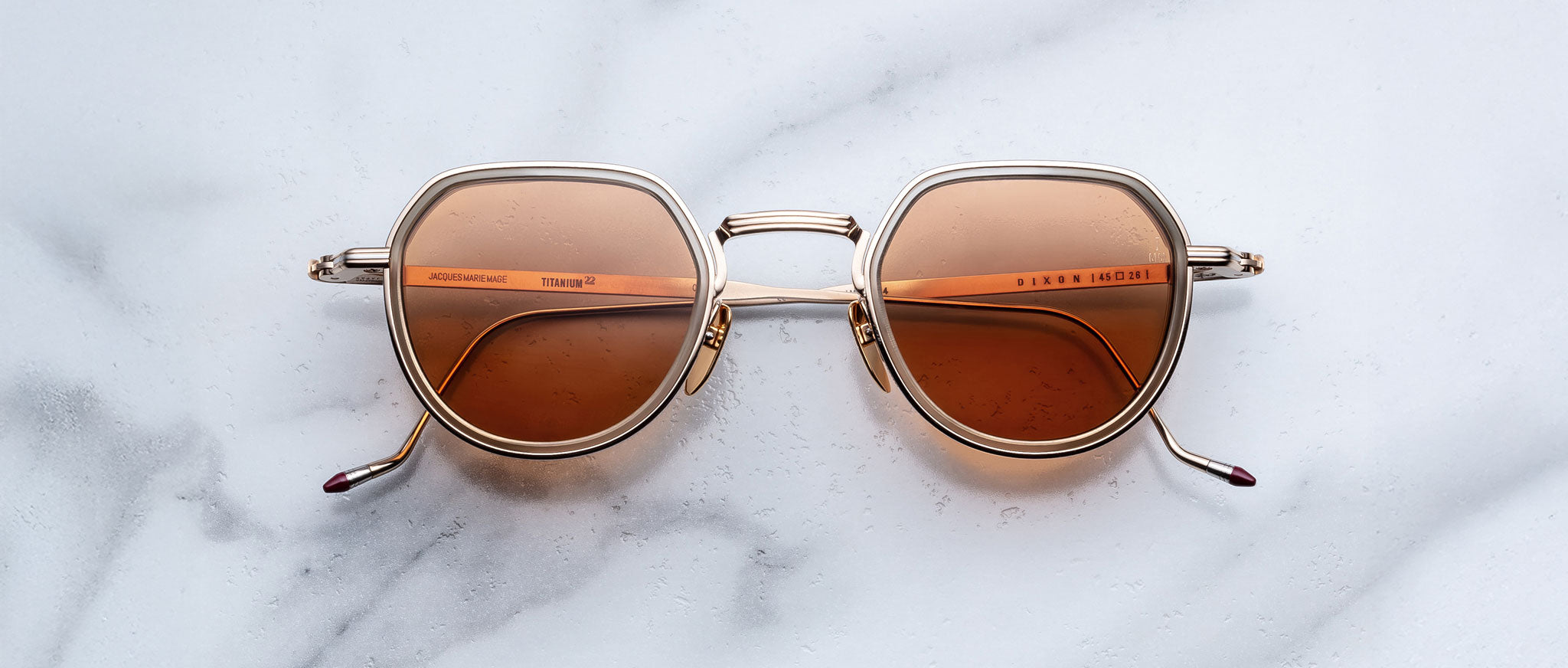 Jacques Marie Mage Dixon sunglasses with gold frames and brown UV lenses shown from above.