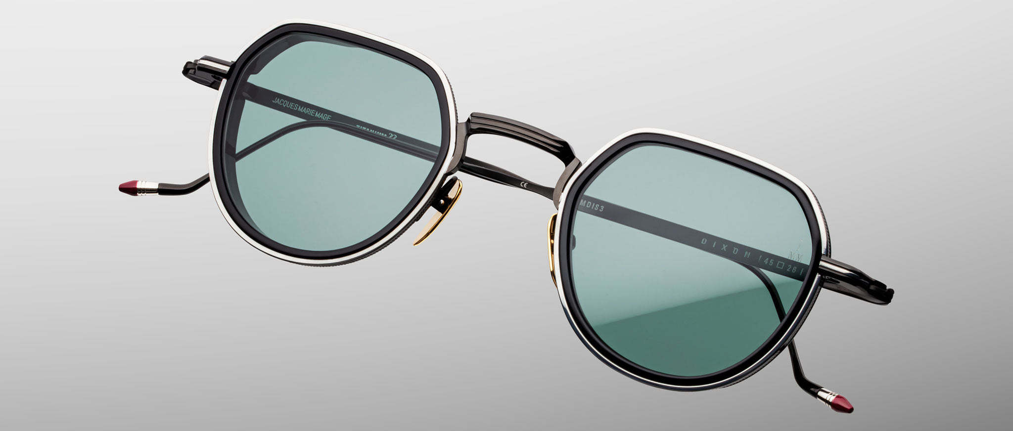 Jacques Marie Mage Dixon sunglasses with hexagonal frames, green lenses, and black arms shown from the front.