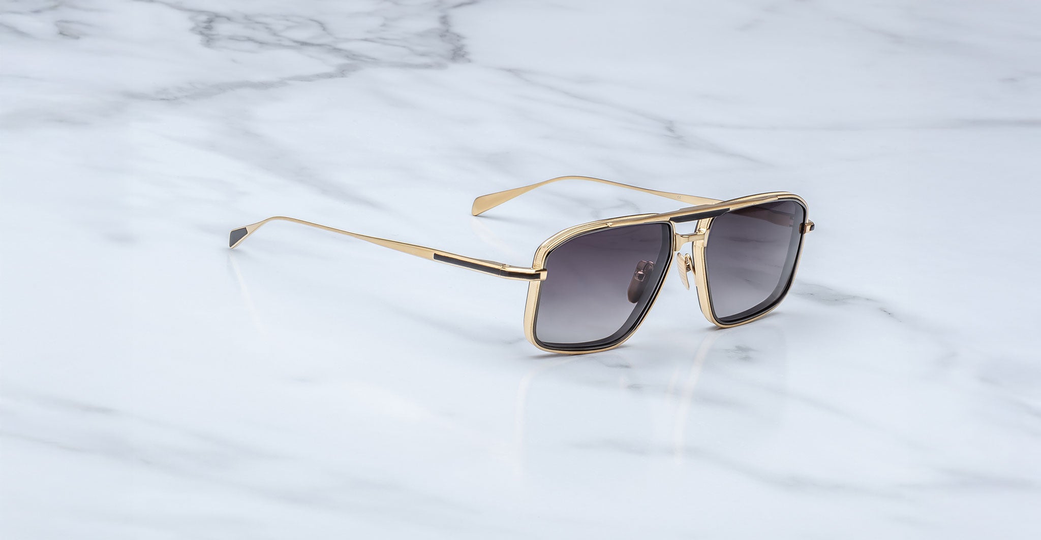 Jacques Marie Mage Earl aviator sunglasses with gold frames and dark lenses shown from above.