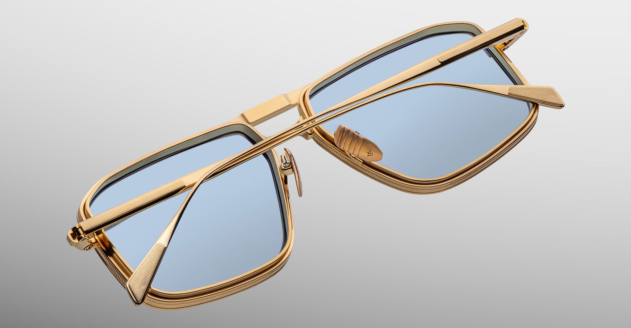 Jacques Marie Mage Earl sunglasses with gold rectangular frames and blue lenses, shown from the front.