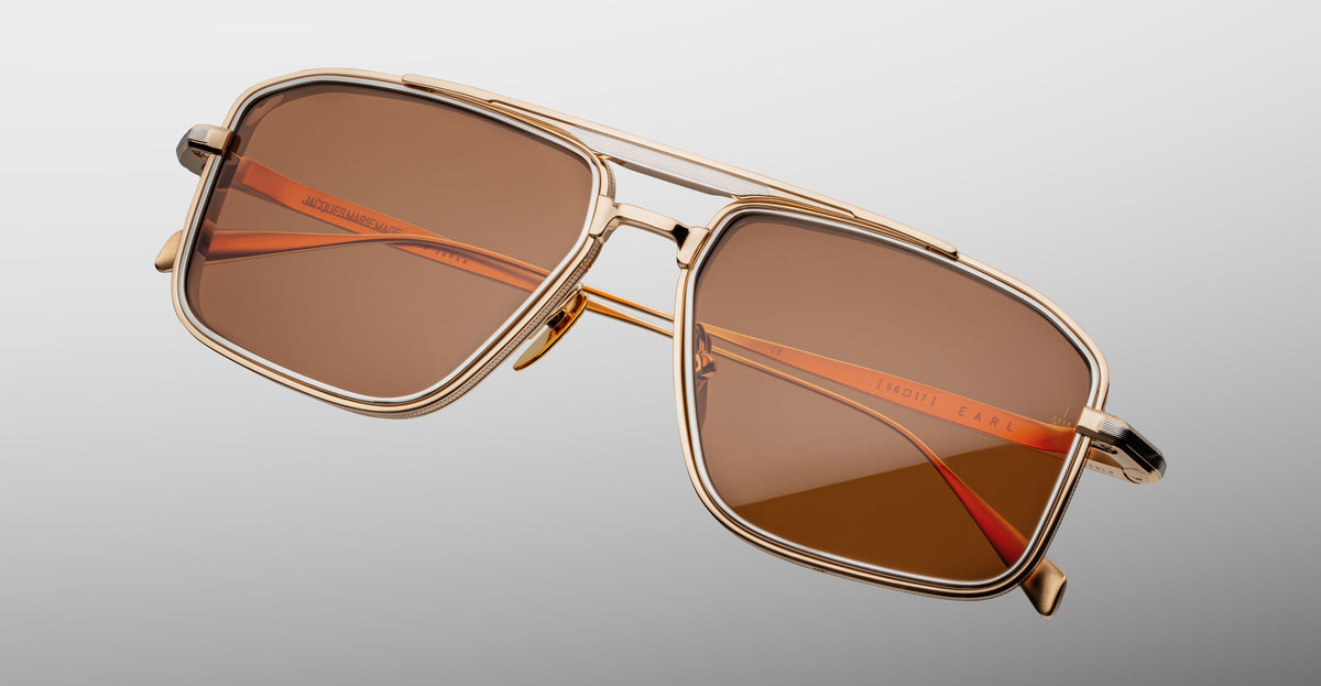 Jacques Marie Mage Earl sunglasses with gold frame, rectangular brown lenses, and orange-tinted arms, front view.