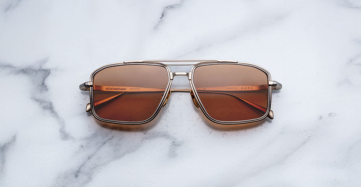 Jacques Marie Mage Earl aviator sunglasses with brown lenses and gold frames, shown from above.