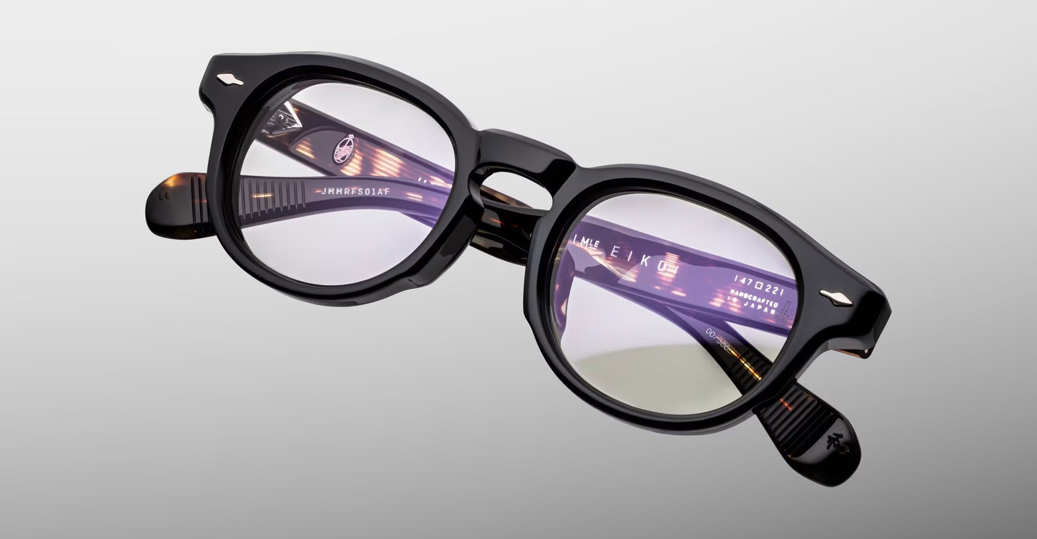 Jacques Marie Mage Eiko eyeglasses, black round frames with clear lenses and inner arm metal accents, front view.