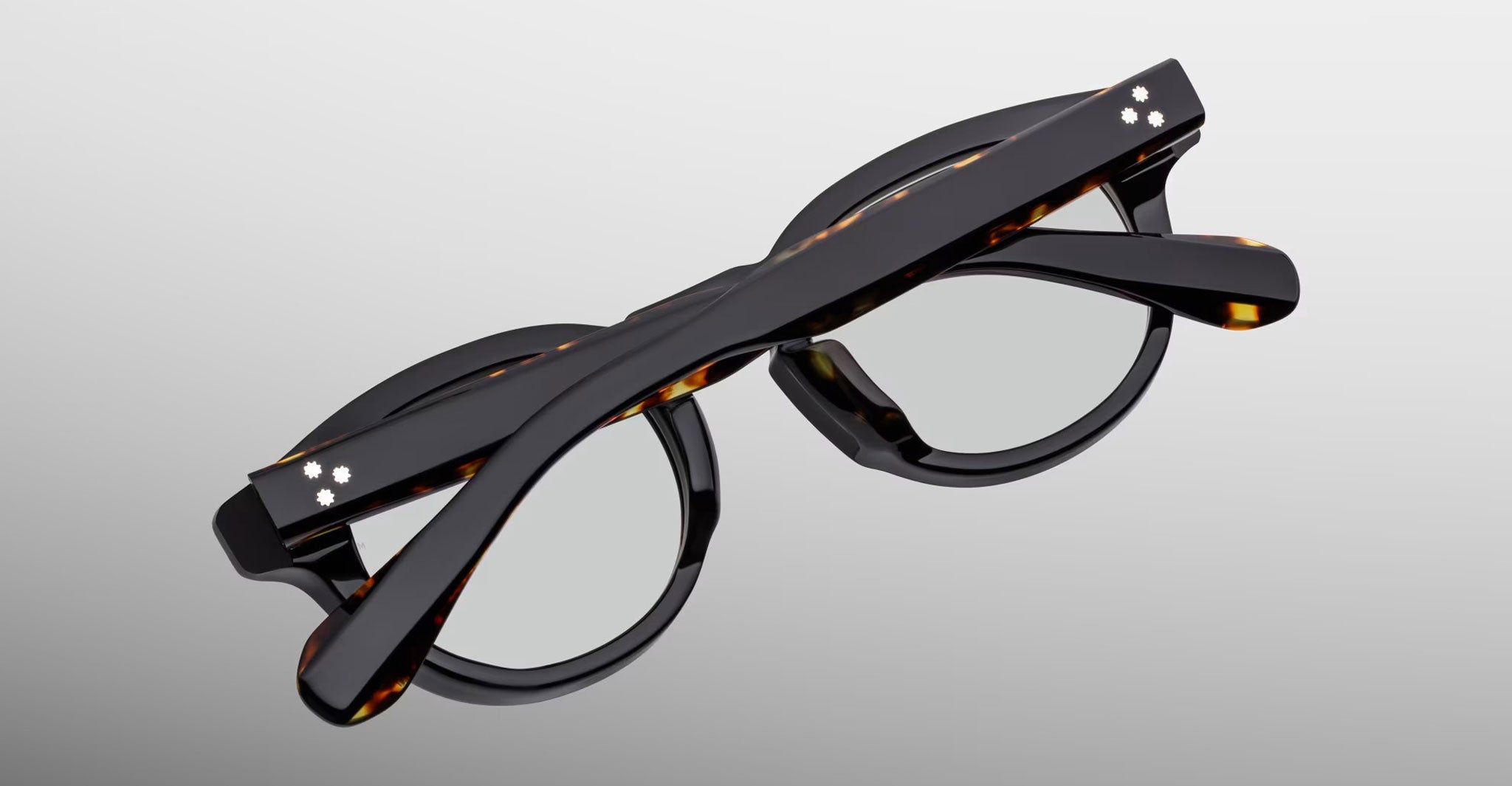 Jacques Marie Mage Eiko eyeglasses in black and tortoiseshell, shown folded from above.