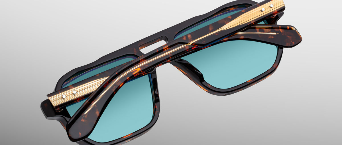 Jacques Marie Mage Evans tortoiseshell sunglasses with blue lenses and gold accents, shown from above.