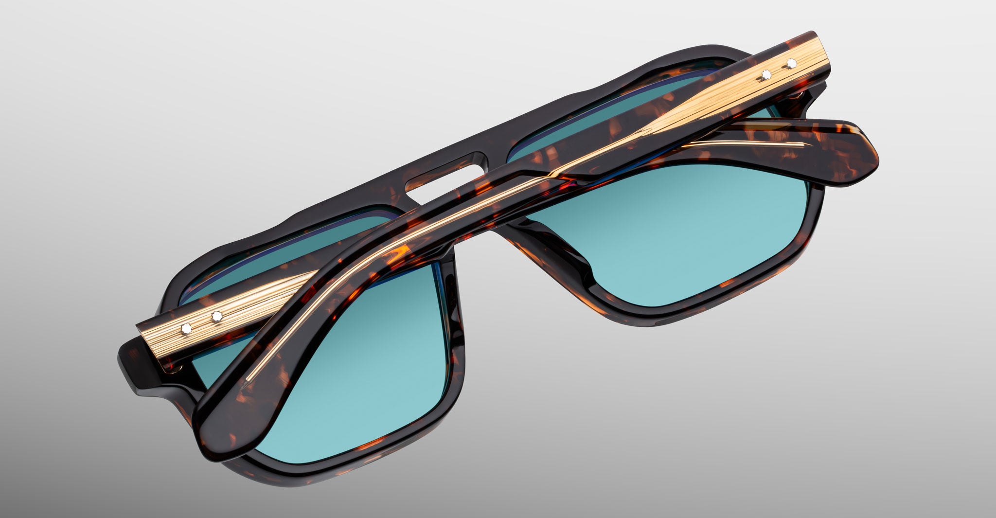 Jacques Marie Mage Evans tortoiseshell sunglasses with blue lenses and gold accents, shown from above.