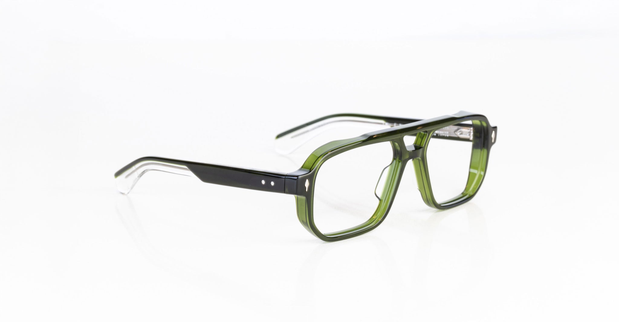The Jacques Marie Mage Evans eyeglasses feature rectangular, thick-rimmed oversized acetate frames in translucent green and black, displayed on a white background.