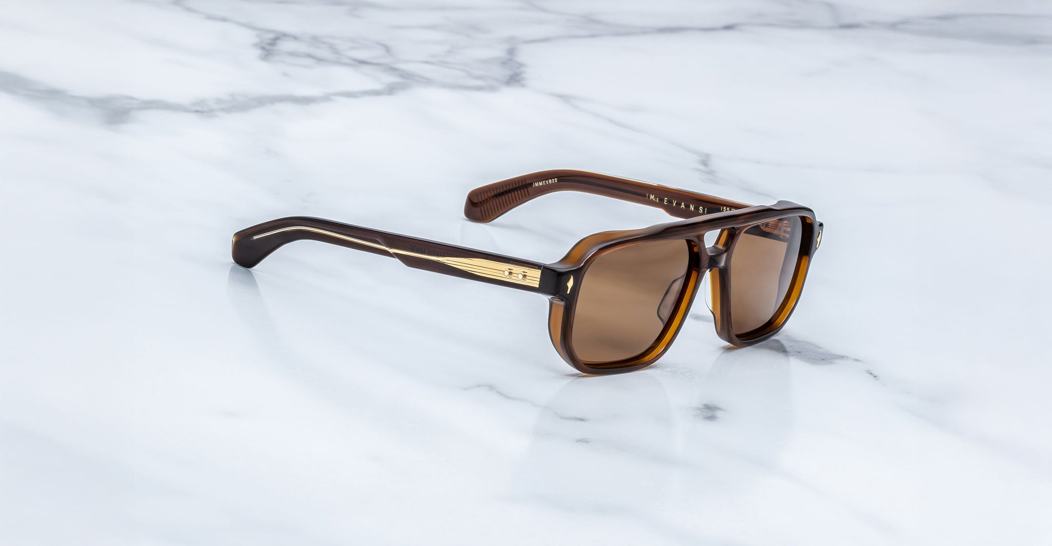 Jacques Marie Mage Evans sunglasses with brown polarized lenses and gold accents shown from above.