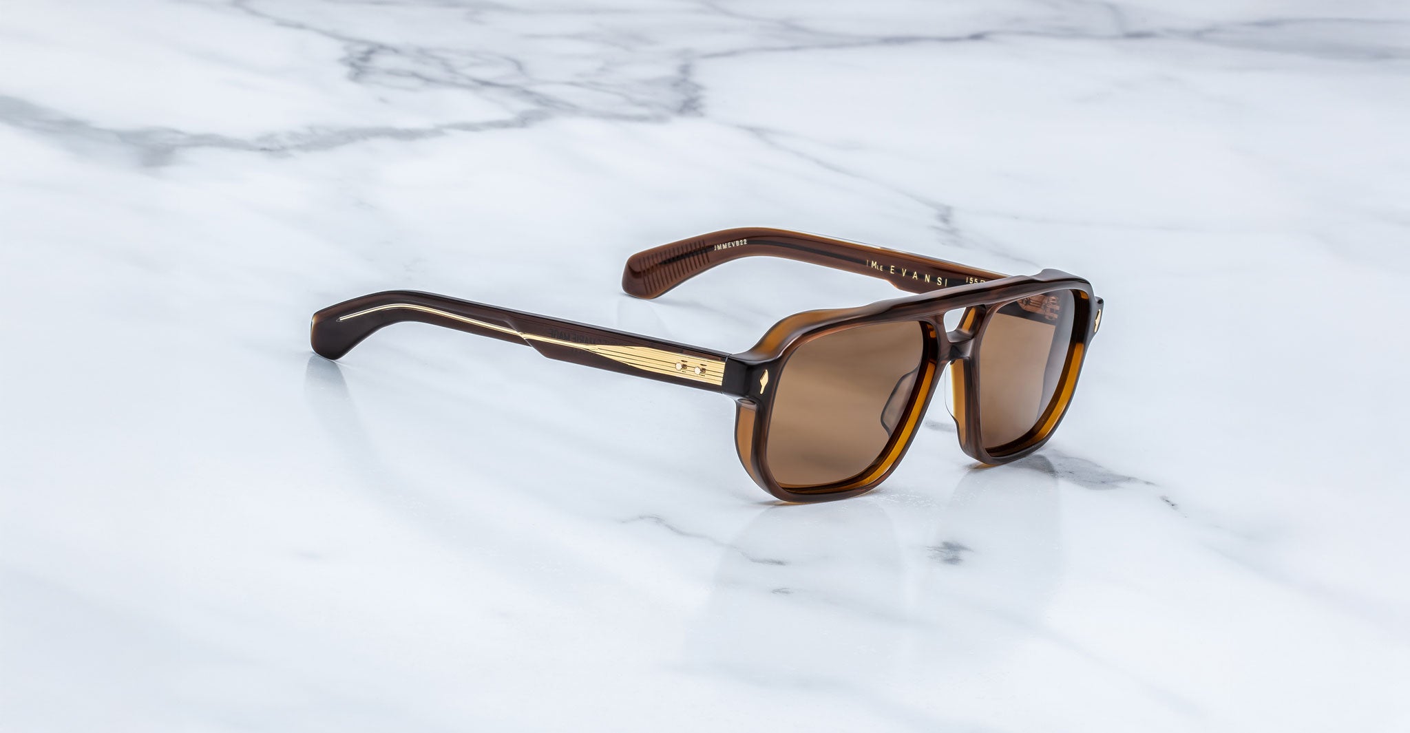 Jacques Marie Mage Evans sunglasses with brown polarized lenses and gold accents shown from above.