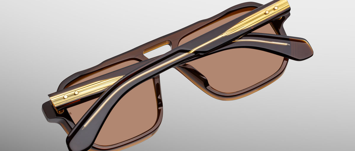 Jacques Marie Mage Evans brown and gold sunglasses, folded, top view. Model and brand name visible.