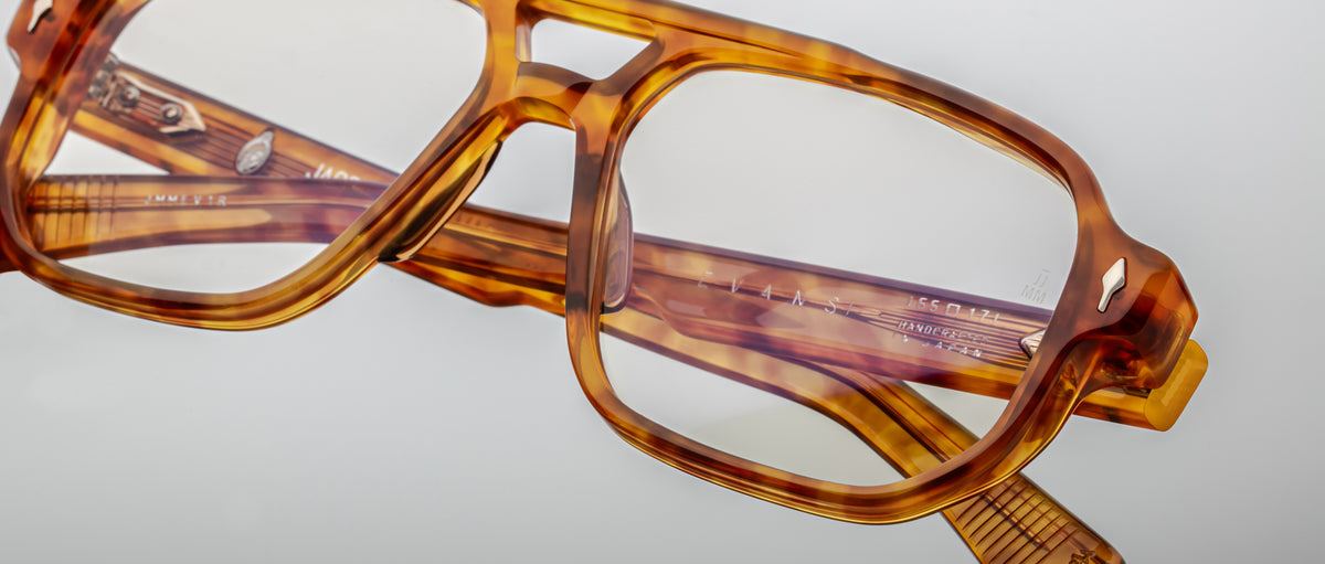 Close-up of Jacques Marie Mage Evans rectangular optical glasses in tortoiseshell, featuring clear lenses and folded neatly on a light gray surface.