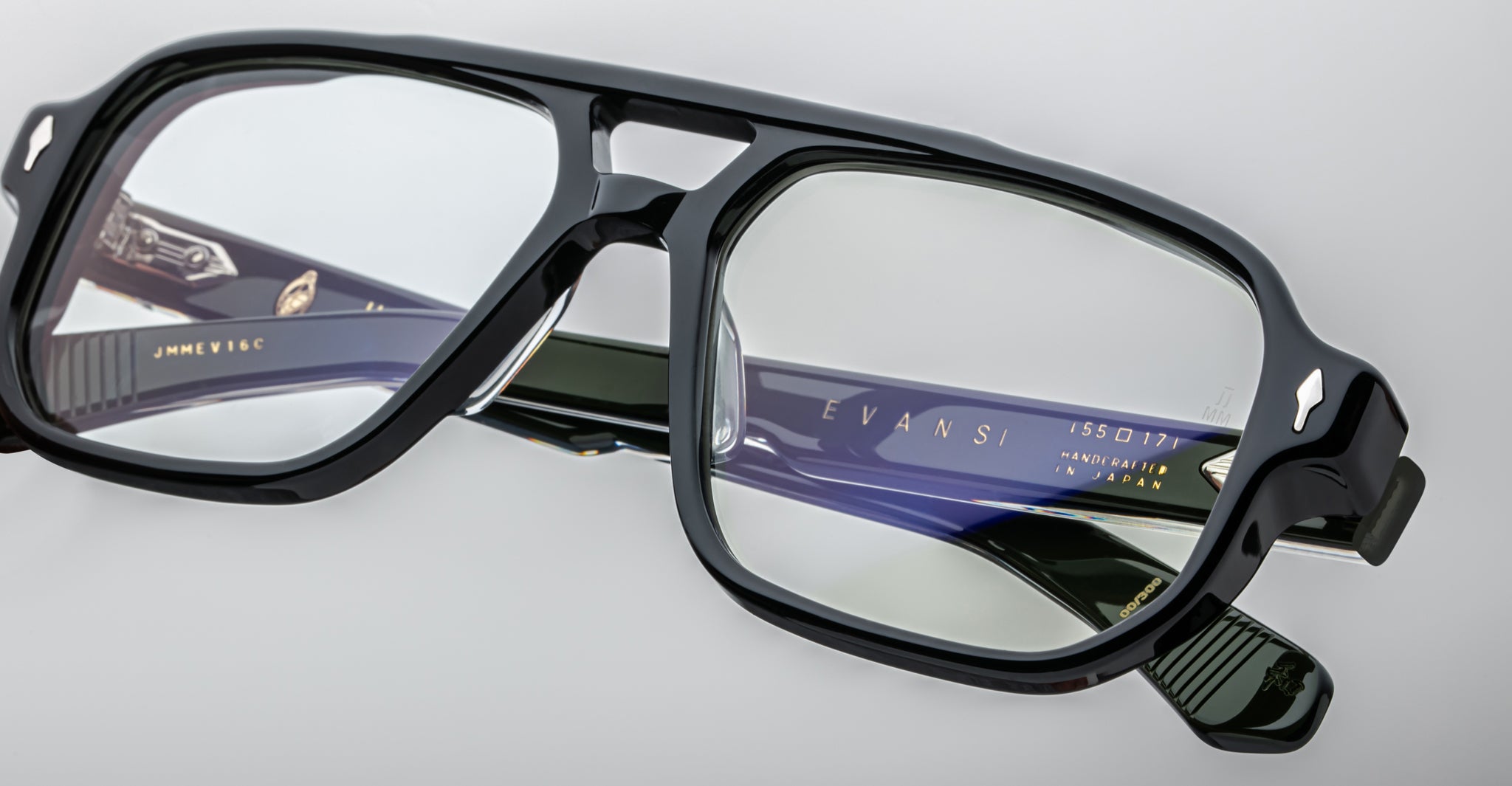 Close-up of Jacques Marie Mage Evans handcrafted optical glasses featuring rectangular lenses and detailed design, with engraved branding on the inside of the oversized acetate temples.