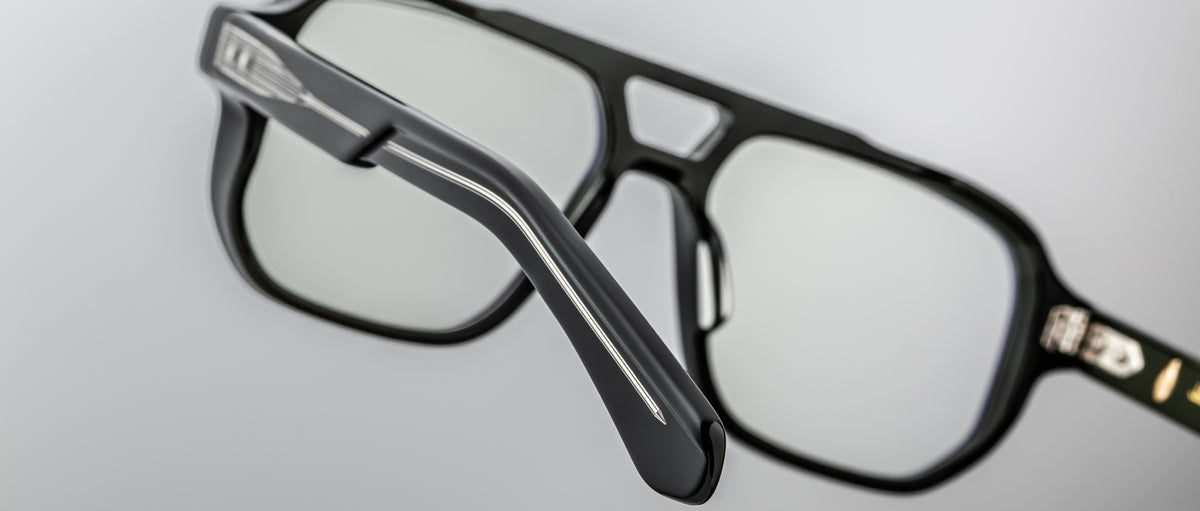 Close-up of Jacques Marie Mage Evans optical glasses showcasing an oversized acetate frame and silver temple detailing, set against a plain light gray background.