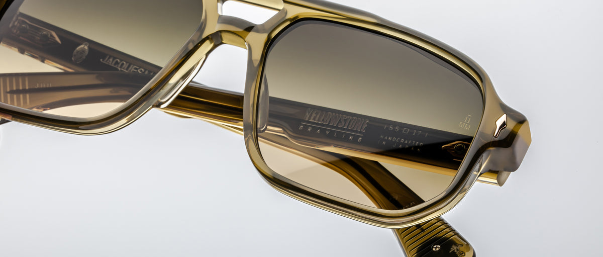 Close-up of Jacques Marie Mage Evans sunglasses in brown acetate with tinted lenses, showcasing oversized rectangular frames and signature branded temple details, all handcrafted by Jacques Marie Mage against a white background.
