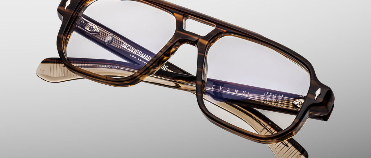 The Jacques Marie Mage Evans features handcrafted oversized acetate frames with brown tortoiseshell rectangular lenses, displayed against a neutral background.
