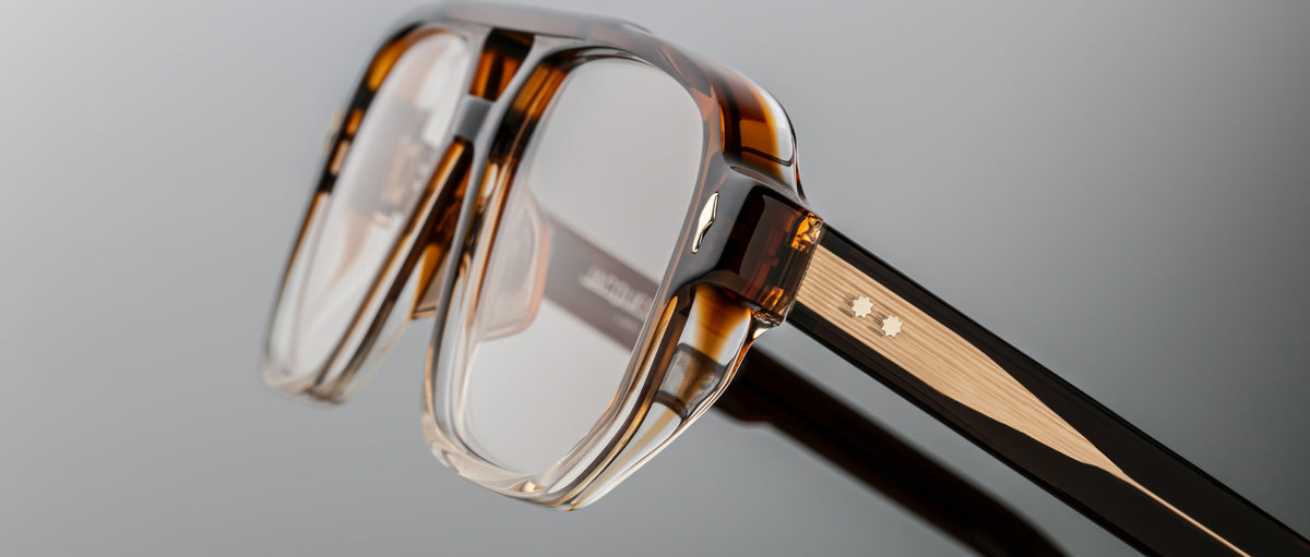 Close-up of Jacques Marie Mage Evans eyeglasses in brown tortoiseshell, featuring clear lenses, an oversized acetate frame with textured detail, and a small metallic accent on the temple.