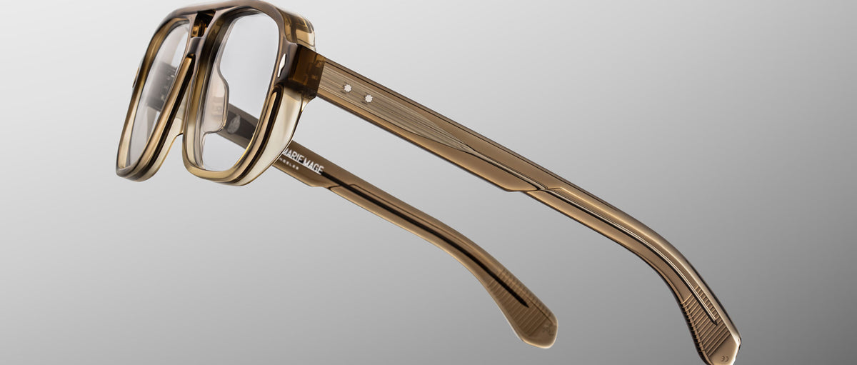 The Jacques Marie Mage Evans glasses showcase an oversized brown translucent rectangular acetate frame, displayed at an angle on a plain gray background.