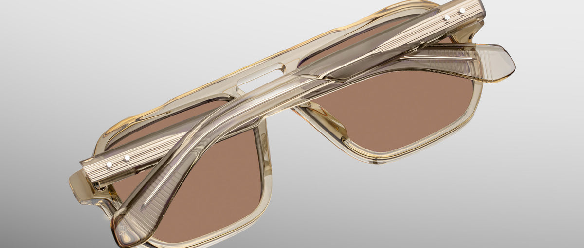 Jacques Marie Mage Evans sunglasses, folded, rectangular shape with translucent beige frames and brown UV lenses, top view.