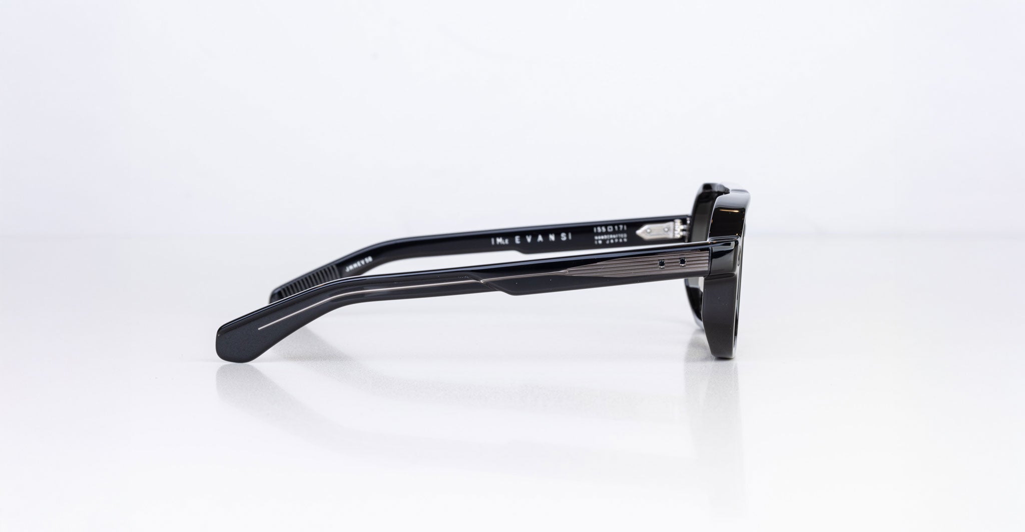 A side view of the Jacques Marie Mage Evans sunglasses showcases their thick, oversized black acetate frame and detailed hinges against a plain white background.
