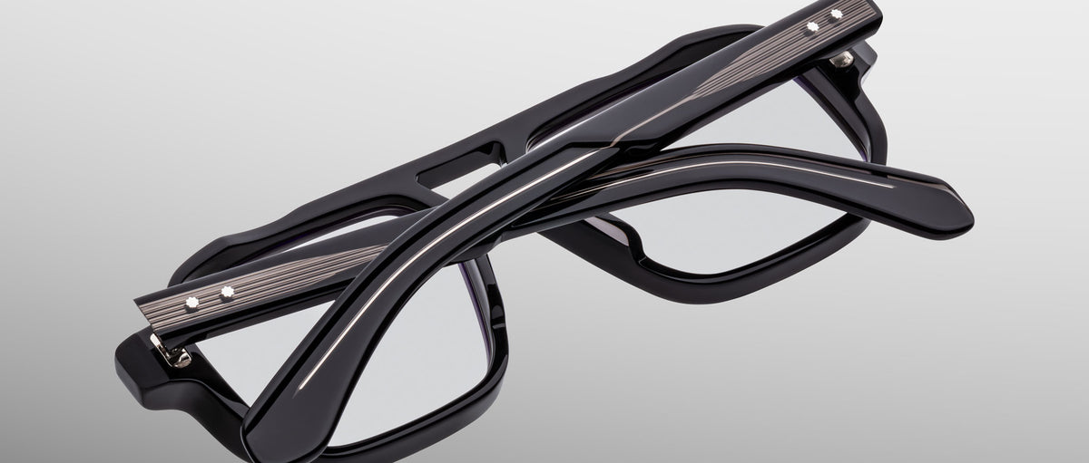 The Jacques Marie Mage Evans, a pair of black handcrafted optical glasses with rectangular frames, is shown folded against a plain light background.