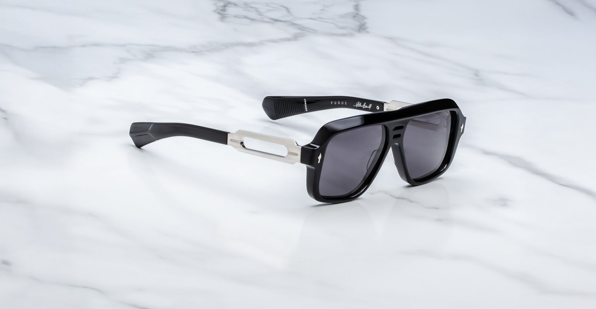 Jacques Marie Mage Fugue sunglasses with silver accents and UV lenses, top-down view.