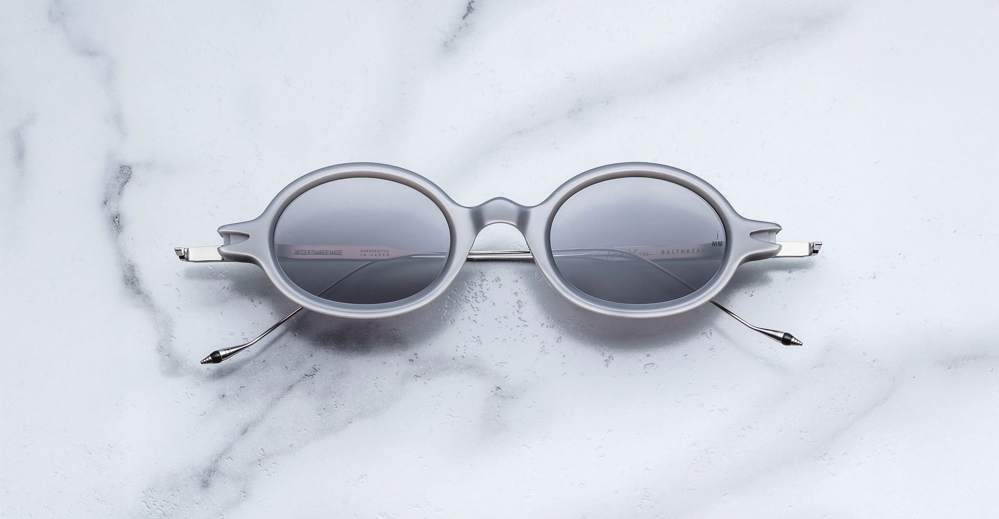 Jacques Marie Mage Balthazar round gray-framed polarized sunglasses with dark lenses, front view.